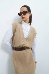 Vestido tejido color beige con escote en V y diseño acanalado.