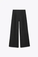 Pantalón palazzo negro de tejido fluido con tiro medio, cintura elástica en la espalda, bolsillos laterales ocultos y pinzas en el delantero.
