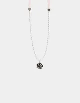 Collar corto de perlas blancas con dije de rosa negra con borde plateado. El collar se ata con cintas de terciopelo rosa pálido.
