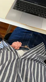 Gargantilla tejida a mano en algodón color rosa, con forma de rosa y tiras para atar.