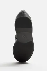 Mocasín de vestir negro con detalle de antifaz en el empeine y suela a tono con ligero tacón.