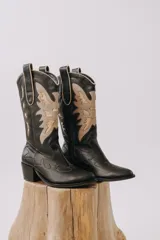 Bota texana negra con bordados en el mismo tono, taco bajo y punta fina.