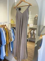 Vestido largo confeccionado en 100% lino de color naranja tierra, con escote en V y tirantes finos. Presenta un diseño fluido y minimalista ideal para la temporada de verano.