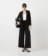 Blazer negro de poliéster con frente cruzado, manga larga, abotonado y bolsillos.