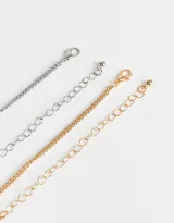 Set de dos collares de cadena metálica, uno plateado y otro dorado, con dije de oso y cristal.