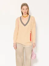 Sweater beige de punto con cuello en V con rayas azul marino y tiras trenzadas rojas y rosas en los laterales.