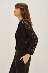 Saco corto de encaje negro con solapas de satén y un botón frontal.