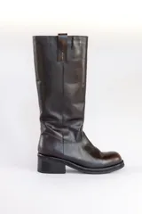 Bota de cuero marrón con caña alta, taco bajo y puntera redondeada.