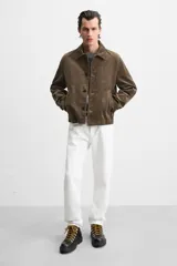 Bota de cuero color marrón oscuro con cordones amarillos, estilo trekking, con suela de goma con volumen.