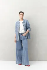 Pantalón de jean negro de calce ultra wide leg, tiro alto y silueta amplia desde la cadera hasta el bajo. Diseño clásico de cinco bolsillos y cierre con botón metálico y cremallera.