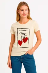Remera color crema con estampado de cerezas rojas y texto "Ma Chérie" en recuadro negro.