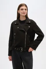 Chaqueta negra con cuello solapa, cierre cruzado con cremallera, cinturón con hebilla, bolsillos laterales con cremallera y detalles de botones metálicos.