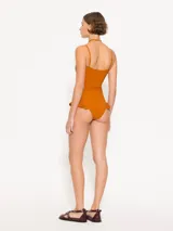 Traje de baño entero color azul marino con escote recto y breteles desmontables. Presenta volados en la cadera.