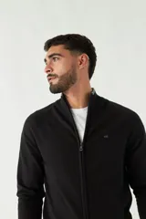 Campera tejida azul marino con cuello alto, cierre frontal y puños acanalados con detalle de línea roja.