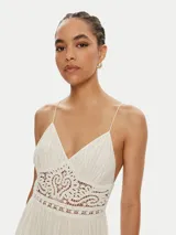 Vestido largo blanco con breteles finos, escote en V y detalle de tejido crochet calado en la cintura. La falda es plisada y termina con un borde de encaje ancho.