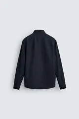 Camisa azul marino de corte regular fit, confeccionada en tejido de algodón con estructura. Tiene cuello solapa, manga larga con puños abotonados y cierre frontal con botones.