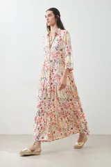 Maxi vestido estampado multicolor con cuello camisero, manga larga y falda larga con volados.