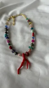 Collar corto de cuentas de colores con dije de coral rojo.