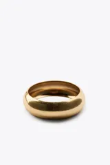 Pack de dos pulseras rígidas, una dorada de metal y otra de resina color crema con veta marrón y aplique de piedra ovalada color coral con engarce dorado.