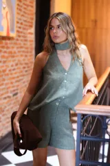 Blusa sin mangas color negro con hilo de lurex plateado, escote en V con botones frontales y choker atado en la espalda.