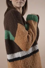 Sweater de lana marrón con rayas horizontales en verde, blanco y naranja. Tiene mangas largas y corte holgado.