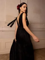 Vestido largo negro con escote en V, breteles finos con lazo y bordados florales a tono. Corte imperio y falda amplia con volados. 