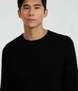 Suéter de punto color borgoña, con cuello redondo, sisas ligeramente desplazadas y bajo y puños acanalados.