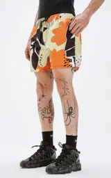 Short de baño con estampado abstracto en tonos naranja, marrón y beige.