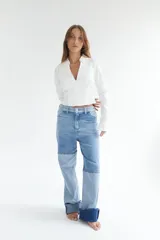 Pantalón de jean con diseño patchwork en diferentes tonos de azul, corte recto y tiro alto.