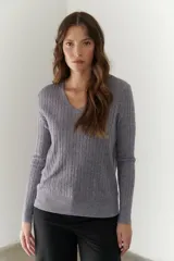 Sweater gris de tejido de punto acanalado, con escote en V y mangas largas.