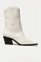 Bota corta de cuero sintético color blanco, estilo texana con bordados decorativos y taco cubano negro.