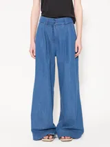 Pantalón de cintura alta confeccionado en denim camisero liviano, color celeste. Presenta piernas amplias con tablas frontales, bolsillos laterales y ojales sastres en la espalda.