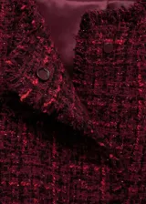 Chaqueta corta de tweed color rojo con cuello redondo, cierre frontal con botones y bolsillos de ribete.