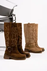Botas de cuero gamuza color marrón con bordado de llamas en la caña, hebilla metálica y taco cuadrado.