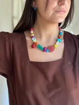 Collar corto con cuentas de cerámica, cristales checos y acrílico de diferentes colores y formas. Incluye una concha roja como dije central.