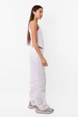Pantalón sastrero recto de poplín color blanco, tiro medio-bajo, con cintura ancha, doble botón a tono y cierre metálico.