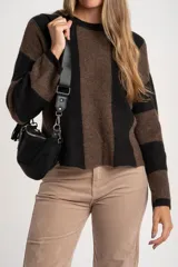 Sweater de tejido de punto grueso, con diseño de rayas verticales anchas en tonos marrón oscuro y negro. Presenta cuello redondo y mangas largas.