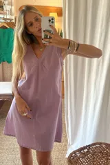 Vestido corto lila con estampado a cuadros, escote en V y sin mangas.