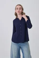 Camisa holgada de manga larga, color azul marino, con cuello mao y dos bolsillos frontales con solapa.