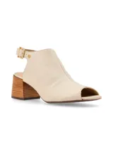 Sandalia peep toe color hueso, confeccionada en cuero, con hebilla metálica y remache metálico con logo de marca. Tiene taco de madera de 6cm, forro y plantilla de cuero, y suela antideslizante de caucho.