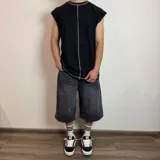 Musculosa blanca de corte holgado con costuras a la vista en cuello, sisas y centro.