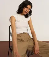 Blusa color crema con cuello redondo y mangas cortas. Presenta un recorte texturizado en el busto y está confeccionada en algodón.