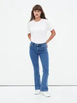 Jean de mezclilla azul de tiro alto, corte ajustado en muslos y pierna acampanada (estilo Oxford o flare).