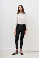 Pantalón negro de corte recto, con paneles de cuero sintético en los laterales y rodillas acolchadas.