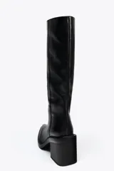 Bota de cuero negra de caña alta, con punta fina y tacón ancho.
