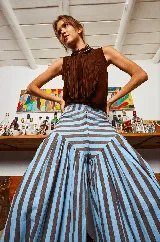 Pantalón babucha de lino con estampado a rayas verticales color celeste y marrón. Presenta corte amplio y tiras para atar en los tobillos.