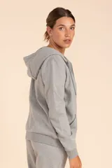 Chaqueta deportiva gris melange con capucha y cierre frontal.