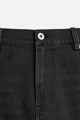 Pantalón de jean negro con corte skinny fit, cinco bolsillos, lavado con efecto roto y cierre frontal con cremallera y botón.