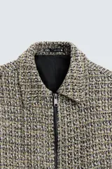 Sobrecamisa de hombre regular fit confeccionada en tejido con estructura irregular en tonos beige, marrón y negro. Tiene cuello solapa, manga larga con puños abotonados, bolsillos laterales y cierre frontal con cremallera.