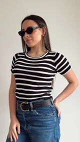 Remera corta de punto con cuello redondo y mangas cortas, a rayas horizontales. Disponible en color rosa con rayas rojas y en color negro con rayas blancas.